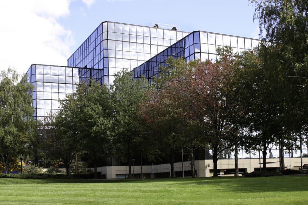 Office or medical building exterior with lawn and trees in foreground